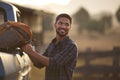 Man Loading Backpack Into Pick Up Truck For Road Trip To Cabin In Countryside Royalty Free Stock Photo