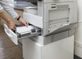 Man loading paper into photocopier`s tray at office