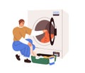 Man loading washing machine with dirty clothes. Person putting linen into washers drum. Guy opening door of Royalty Free Stock Photo