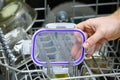 A man loads dirty dishes, plates, spoons, forks, cutlery into dishwasher tray Royalty Free Stock Photo