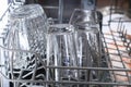 A man loads dirty dishes, plates, spoons, forks, cutlery into dishwasher tray. Royalty Free Stock Photo