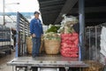 Man loads a truck with onions and vegetables at the nightly flower market Pak Klong Thalat in Bangkok