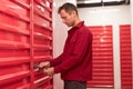 Man Locking Storage Unit in Warehouse