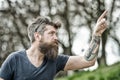 Man with long beard and mustache pointing upwards with finger, defocused background. Guy looks cool with stylish beard Royalty Free Stock Photo