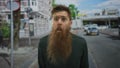 Man with long beard widens eyes on street; curiosity introspection reflection Royalty Free Stock Photo