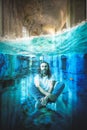 Man with long hair and beard meditates underwater