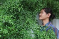 A man with a Long hair and a mustache peeking out from the bushes of Terminalia ivorensis Chev bedew