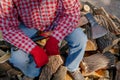 Lumberjack with big ax sits on pile of firewood