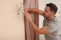 Man looking at affected with mold wall in room Royalty Free Stock Photo