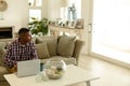 Man looking away while working on laptop on sofa in living room Royalty Free Stock Photo