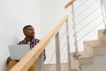 Man looking away while working on laptop on stairs in a comfortable home Royalty Free Stock Photo