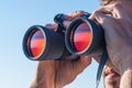 A man looking through the binoculars