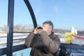 The man looking in binoculars from a ferris wheel cabin Royalty Free Stock Photo