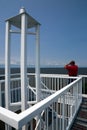 Man Looking Through Binoculars at Top of Harbor Light