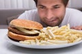 Man Looking At Burger And French Fries Royalty Free Stock Photo