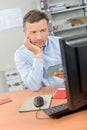Man looking at computer cross referencing Royalty Free Stock Photo