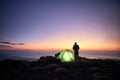 Man Looking Dawn On The Sea From His Illuminated Tent