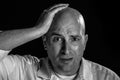 Man Looking Exasperated While Clutch His Head With His Hand in Black and White
