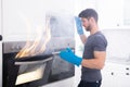 Man Looking At Fire Coming Out From Oven