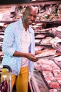 Man looking at goods in grocery section while shopping in supermarket Royalty Free Stock Photo