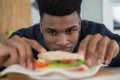 man looking at sandwhich