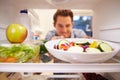 Man Looking Inside Fridge Full Of Food And Choosing Salad Royalty Free Stock Photo