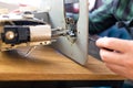 Man is looking inside sewing machine trying to repair it, hands closeup. Royalty Free Stock Photo