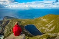 Man looking at a lake in a hill on Achill island, Co. Mayo.