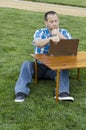 Man looking at a laptop outdoors.