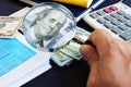 Man looking through magnifying glass on a dollar banknote. Audit and financial research. Royalty Free Stock Photo