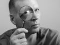 Man looking through magnifying lens glass portrait, investigating, inspecting you Royalty Free Stock Photo