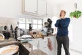 Man looking at the messy kitchen in then morning, full of rubbish and dirty dishes Royalty Free Stock Photo