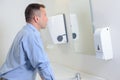 Man looking in mirror in restroom Royalty Free Stock Photo