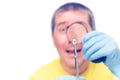 Man looking at mite through magnifier, on white background