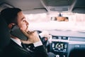Business Man looking at mobile phone while driving a car. Royalty Free Stock Photo