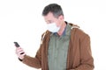 Man looking mobile phone in surgical mask protective face Covid virus COVID-19 Royalty Free Stock Photo