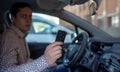 Man looking out from car window and holding a car alarm key Royalty Free Stock Photo