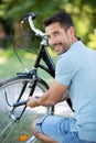 man looking over shoulder while inflating bicycle tyre Royalty Free Stock Photo