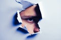 Man looking through paper. A jealous husband. Hole torn in paper with the eye of boy. Portrait of man looking through Royalty Free Stock Photo