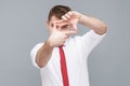 Man looking through photo frame made of hands, focusing and cropping image Royalty Free Stock Photo