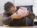 Man Looking at Piggy Bank Royalty Free Stock Photo