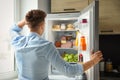 Man looking into refrigerator full of products Royalty Free Stock Photo