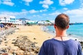 A man looking at seaside promenade in Playa Blanca, the former fishermens village became a main touristic spot with opening of the