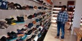 Man looking at sport shoes corner for buying something