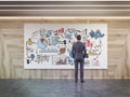 Man looking at startup sketch in wooden walls room Royalty Free Stock Photo