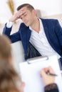 Man looking stressed woman holding clipboard