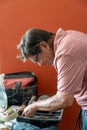 Man looking for tools in his toolbox with a screwdriver in hand