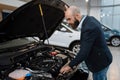 Man looking on transport engine in car dealership