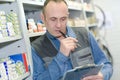 Man looking up on clip-board in inventory stock warehouse