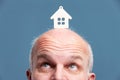 Man looking up at a model house on his forehead Royalty Free Stock Photo